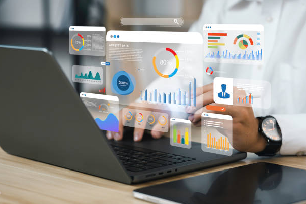 Professional using laptop with financial dashboards and analytics displayed as digital overlays, showing charts, graphs, and business intelligence data